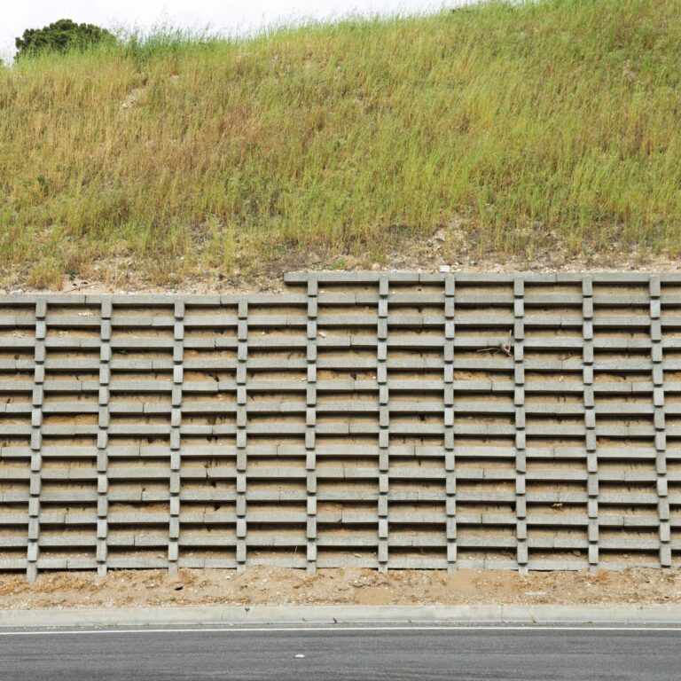 Crib retaining wall with interlocking concrete cells on a roadside slope